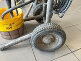 a wheel that is sitting on the ground next to a bucket
