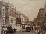 une vieille photo d'une rue de la ville où l'on voit des gens et des voitures