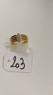 gros plan d'une bague en or surmontée d'un diamant