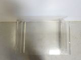 a clear plastic box on the floor next to a white wall