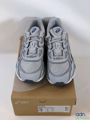 a pair of white sneakers sitting on top of a cardboard box