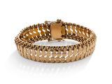 gros plan d'un bracelet en or sur fond blanc