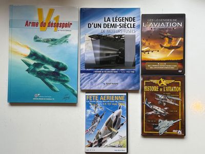 plusieurs livres posés sur une table, sur laquelle se trouve un ordinateur portable