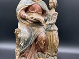 une image représentant une statue d'une femme tenant un enfant et une pomme