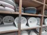 many plates and bowls on the shelves in the room