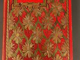 the front cover of a red book with gold flowers on it