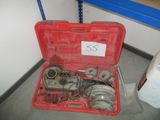 une boîte à outils rouge contenant des outils, posée par terre