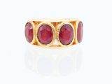 une image représentant une bague en or sertie de pierres rouges sur un fond blanc