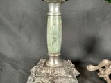 a silver vase with flowers in it sitting on a table
