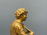 figurine en or représentant un joueur de baseball tenant une batte, posée sur un socle en marbre