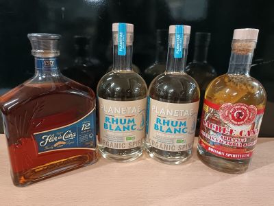 trois bouteilles d'alcool sont alignées sur un comptoir