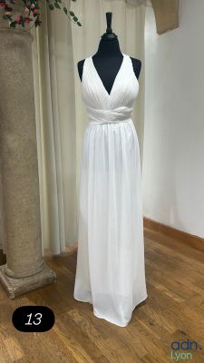 a white dress on a mannequin stand in a room