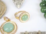 a lot of jewelry on a white table with a flute