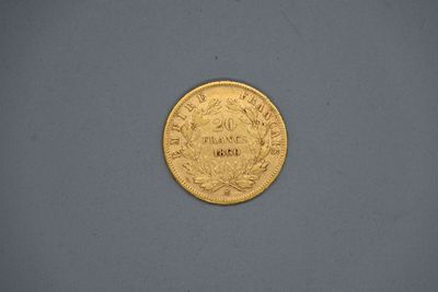 une pièce d'or posée sur une surface grise, sur fond blanc