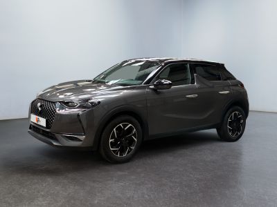un SUV gris garé dans une pièce aux murs blancs
