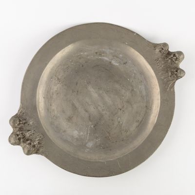 a silver plate with a flower decoration on it