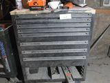 une armoire à outils sur laquelle sont posés des outils, dans un garage