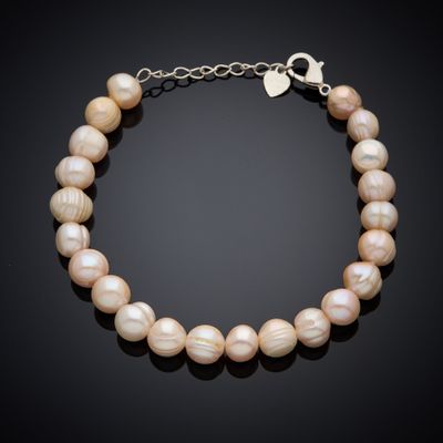 a pearl bracelet with a silver clasp on a black background