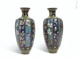 une paire de vases posés l'un à côté de l'autre sur une surface blanche