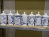 six boîtes bleues et blanches sont alignées sur une étagère