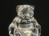 un ours en verre posé sur une surface noire