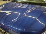 a blue sports car parked in a garage with other cars