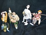 five figurines of people sitting on a chair