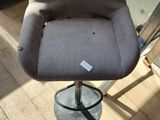 a grey chair that is sitting on a wooden floor