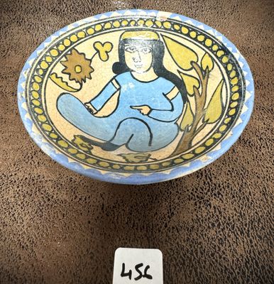 un petit bol sur lequel est représentée une femme