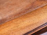 a wooden table with a leather top on it