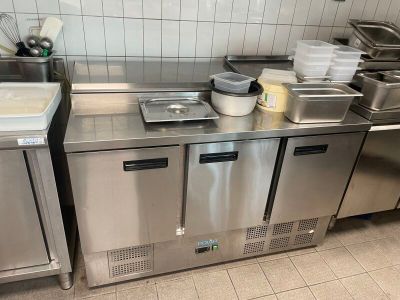 une cuisine avec de nombreux plans de travail en inox