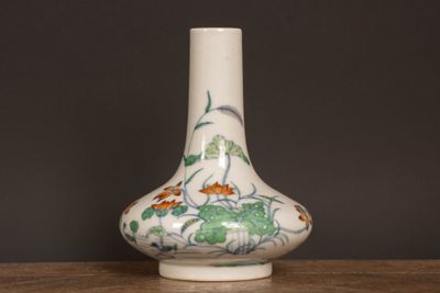 un vase blanc orné d'un motif floral, posé sur une table