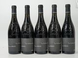 six bottles of wine are lined up in a row on a white surface