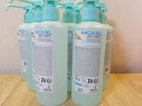trois flacons de gel hydroalcoolique posés sur une table en bois