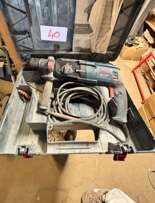 une photo d'une boîte à outils contenant une perceuse filaire