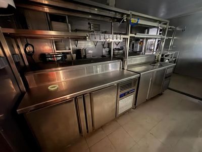 une cuisine équipée de plans de travail et d'appareils électroménagers en acier inoxydable