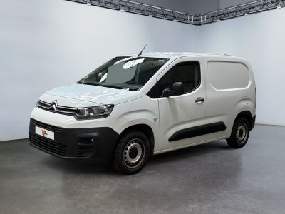 La camionnette blanche est garée dans une grande pièce aux murs blancs