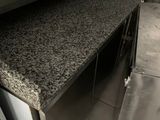 une photo d'une cuisine professionnelle équipée de plans de travail en granit et d'appareils électroménagers en acier inoxydable