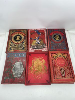 six livres sont alignés sur une surface blanche