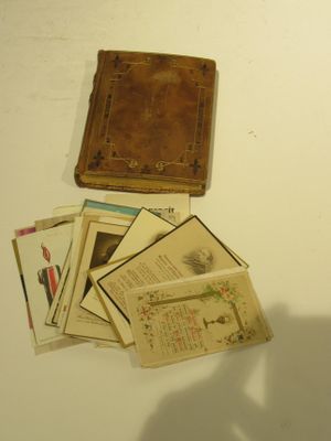 un livre marron et plusieurs vieux livres posés sur une table