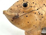a small wooden animal with holes in it ' s body