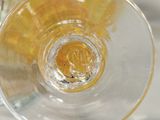 a close up of a wine glass with a yellow liquid inside of it