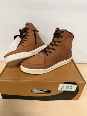 une paire de baskets marron posée sur une boîte en carton