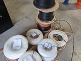 plusieurs rouleaux de fils noirs et blancs sur une palette dans un entrepôt