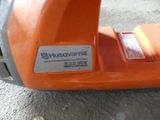 an orange lawn mower sitting on top of a sidewalk next to a sidewalk