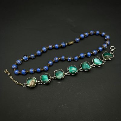 un gros plan sur un collier composé de perles bleues et vertes