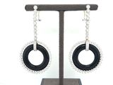 black and white earrings with a circular design hanging from a stand