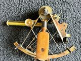 an old brass sexet with a wooden handle on a carpet