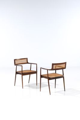 a pair of chairs with cane backrests on a white background