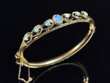 a gold bracelet with oplites and diamonds